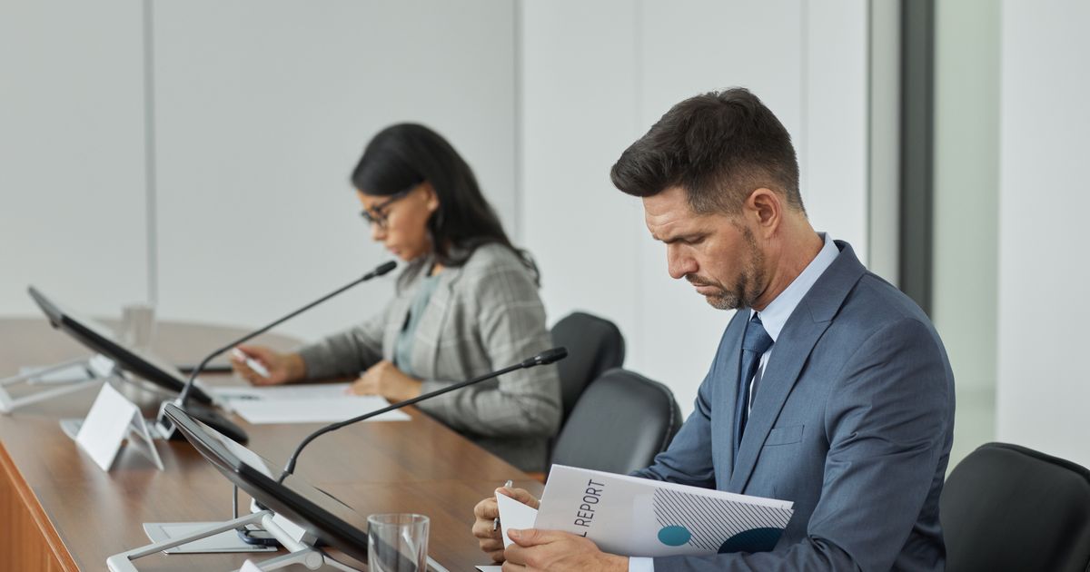Conselho de condomínio analisando documentos técnicos em reunião